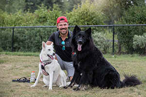 Photo of a man with his two dogs at Lacombe Lake Dog Park