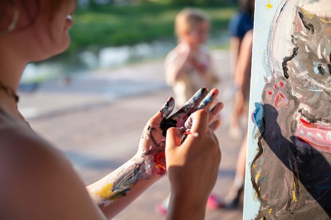 The hands of a painter covered in paint.