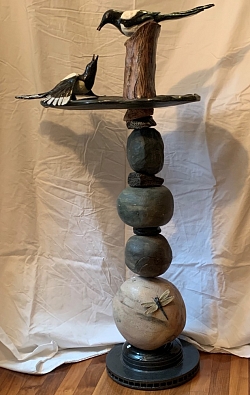 Clay sculpture of two magpies on a platform.