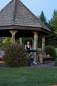 Musician playing piano and singing under the gazebo in the park.