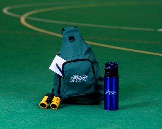Image shows City of St. Albert green backpack, blue water bottle and small yellow binoculars