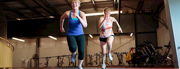 Photo of two women sprinting on the track at Servus Place