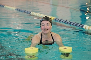 woman using aquatic exercise equipment in pool