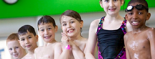 Photo of six kids standing in the pool