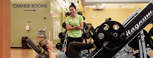 Fitness personal trainer with client lifting weights