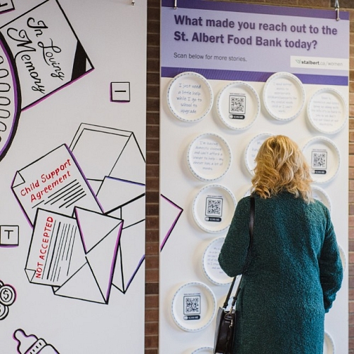 A woman looks at the 2023 International Women's Day art installation 'Have a seat at our table'