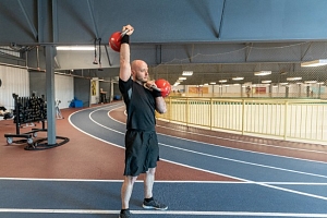 Man lifting kettlebells on track