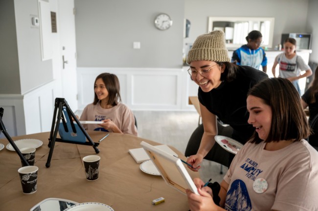 Two young artists getting instruction from a visual art teacher.