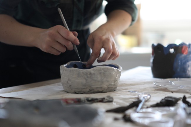 Hands working on a molding clay into a bowl.