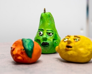 Sculpture of three fruit with faces