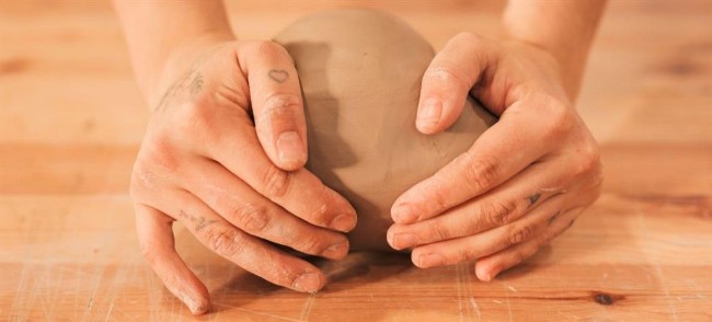 Hands around a ball of clay