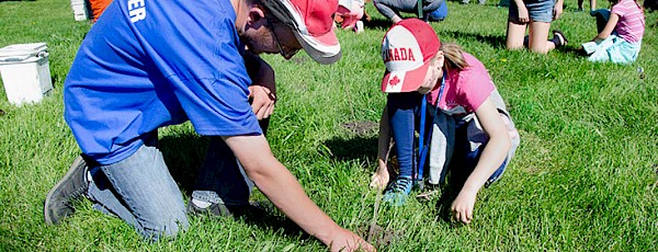 Photo from Spruce Up with people helping to plant trees along the river