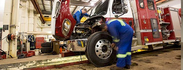 Two Public Works staff working on firetruck