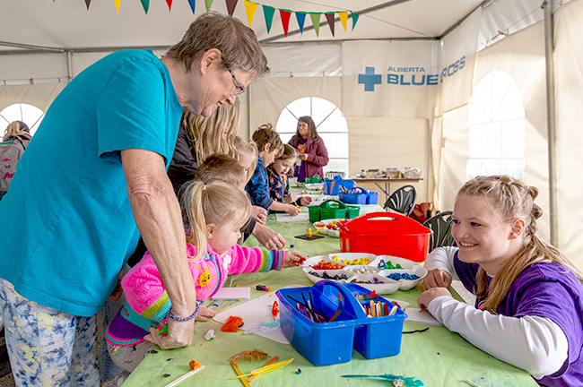 Two volunteers helping a child with an art project