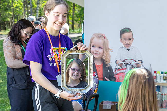 A volunteer holding a mirror for a child