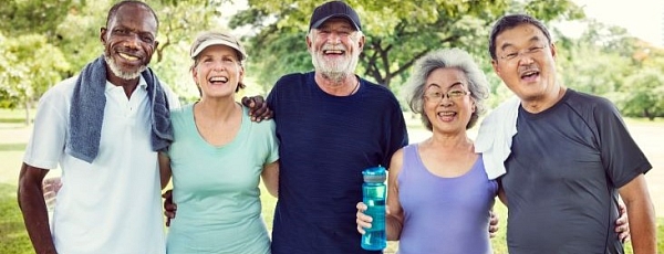 A diverse group of seniors exercise outdoors together