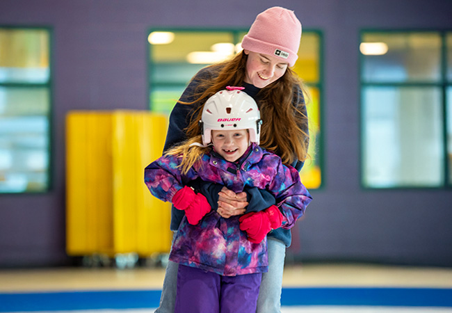 two people learning to skate