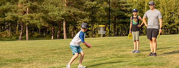 Three people playing disc golf