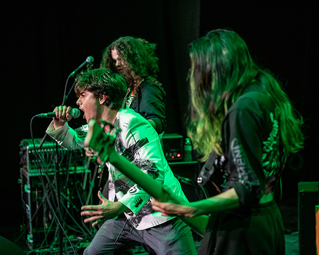 Three performers performing on stage