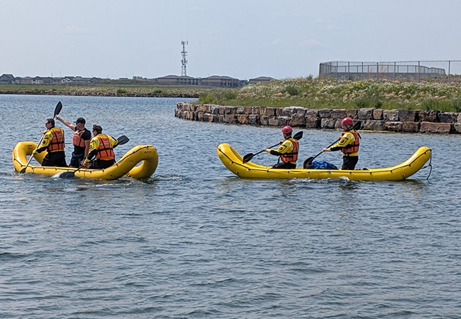 People training in inflatable rafts in a body of water