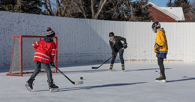 People playing hockey at a boarded rink