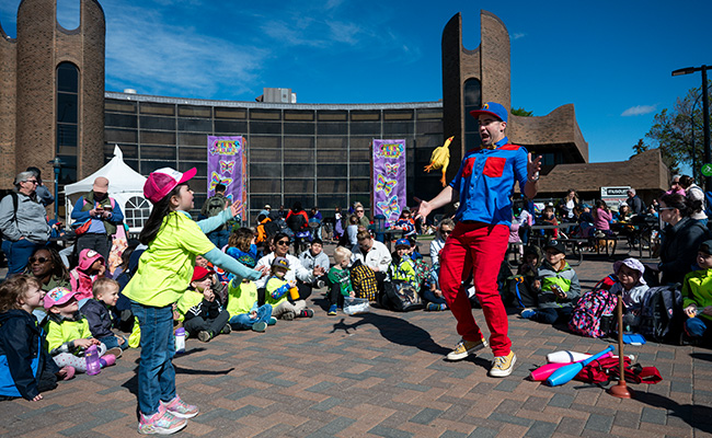 Child throwing a rubber chicken at a performer