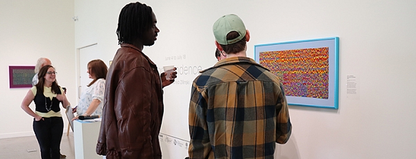 People looking at art on a wall