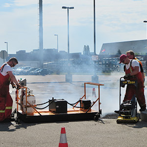 A crew compressing fresh asphalt