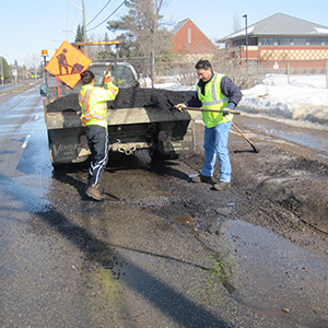 A crew fills a pothole