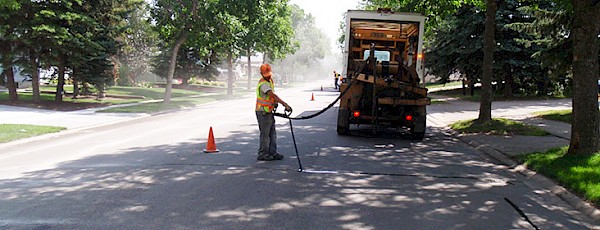 A City employee performs a crack repair